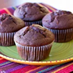 Freshly baked chocolate muffins with chocolate chips on a wooden tray