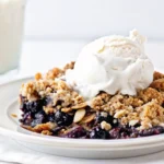 Delicious homemade blueberry crisp in a baking dish topped with oats and butter.