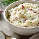Creamy garlic mashed red potatoes topped with fresh herbs and a drizzle of olive oil