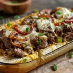 A delicious savory keto philly cheesesteak served on a plate with melted cheese and bell peppers