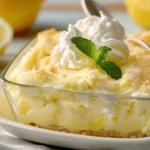 A creamy bowl of tangy lemon cream cheese topped with lemon zest and fresh herbs, served with crackers.