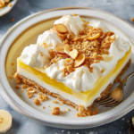 A delicious slice of banana cream pie topped with whipped cream and banana slices on a white plate