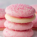 A plate of beautifully decorated pink sugar cookies with sprinkles and a glass of milk