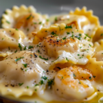 A plate of shrimp ravioli in creamy garlic sauce garnished with parsley and cherry tomatoes